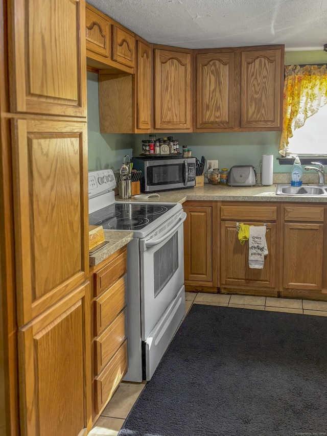 6 Peach St, Waterbury, CT 06708 - kitchen with stainless steel microwave, white electric stove, a sink, light tile patterned flooring, and brown cabinets