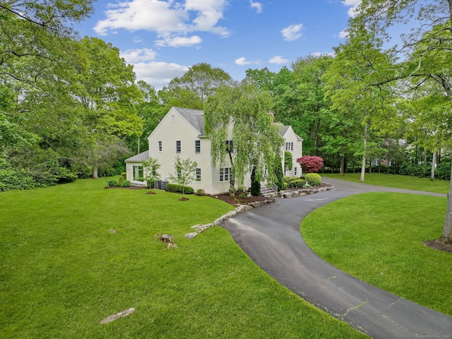 22 Fox Run, Wilton, CT 06897 - view of side of property with a lawn, view of wooded area, driveway, and central AC