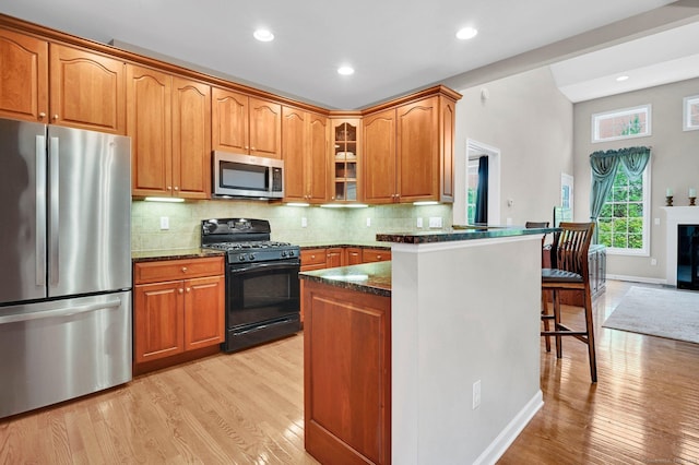 49 Bannan Ln Unit 49, Berlin, CT 06037 - kitchen featuring stainless steel appliances, dark stone countertops, light wood-style flooring, glass insert cabinets, and recessed lighting