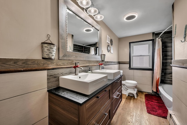 74 Belmont St, New Britain, CT 06053 - bathroom featuring a baseboard heating unit, tile walls, vanity, wood finished floors, and toilet