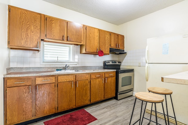 45 Kossuth St, New Haven, CT 06519 - kitchen featuring stainless steel electric stove, freestanding refrigerator, under cabinet range hood, backsplash, and light wood finished floors