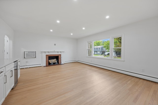 27 Hickory St, Plymouth, CT 06786 - unfurnished living room with light wood finished floors, a wall mounted air conditioner, a baseboard heating unit, baseboard heating, and a brick fireplace