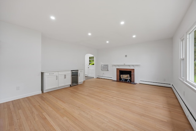 27 Hickory St, Plymouth, CT 06786 - unfurnished living room with a baseboard radiator, a wall mounted air conditioner, arched walkways, light wood finished floors, and recessed lighting