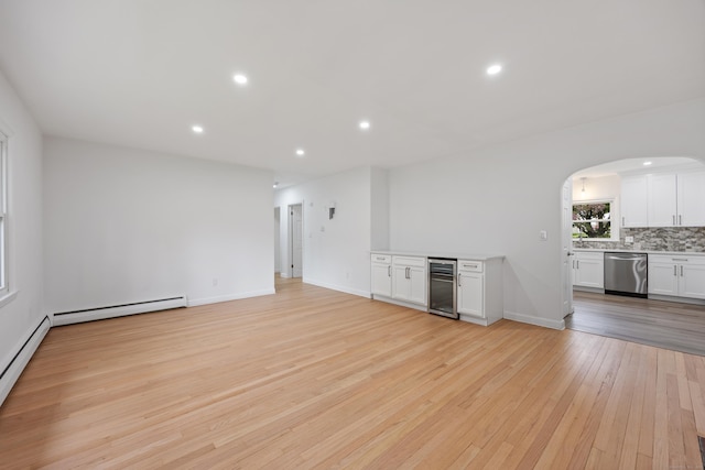 27 Hickory St, Plymouth, CT 06786 - unfurnished living room with beverage cooler, arched walkways, light wood finished floors, recessed lighting, and baseboard heating