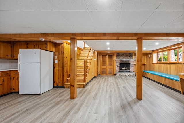 27 Hickory St, Plymouth, CT 06786 - below grade area featuring freestanding refrigerator, a paneled ceiling, light wood-type flooring, stairs, and wood walls