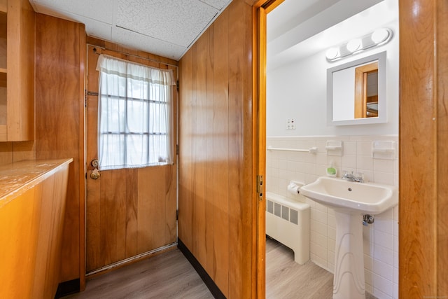 27 Hickory St, Plymouth, CT 06786 - bathroom featuring radiator, wood finished floors, tile walls, a sink, and a wainscoted wall