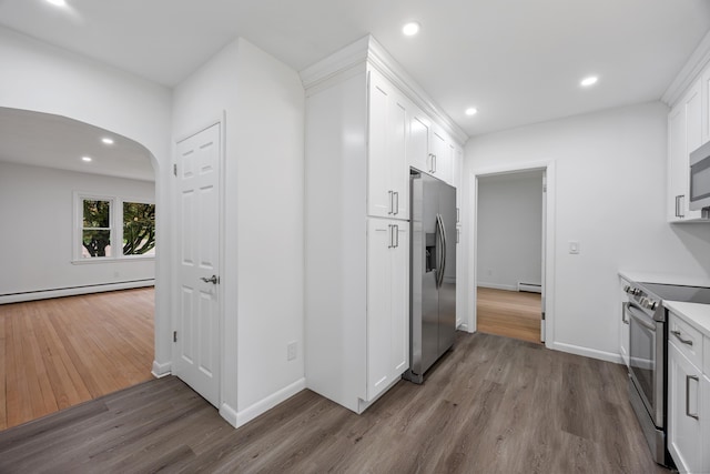 27 Hickory St, Plymouth, CT 06786 - kitchen featuring appliances with stainless steel finishes, a baseboard radiator, wood finished floors, arched walkways, and white cabinets