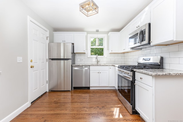 12 Pleasant Dr, Hamden, CT 06514 - kitchen with stainless steel appliances, a sink, decorative backsplash, and white cabinets