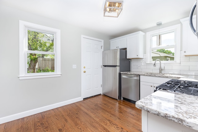 12 Pleasant Dr, Hamden, CT 06514 - kitchen featuring stainless steel appliances, a sink, light stone countertops, backsplash, and white cabinets