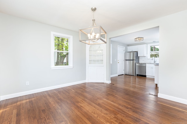 12 Pleasant Dr, Hamden, CT 06514 - unfurnished dining area with a chandelier, healthy amount of natural light, and dark wood-type flooring