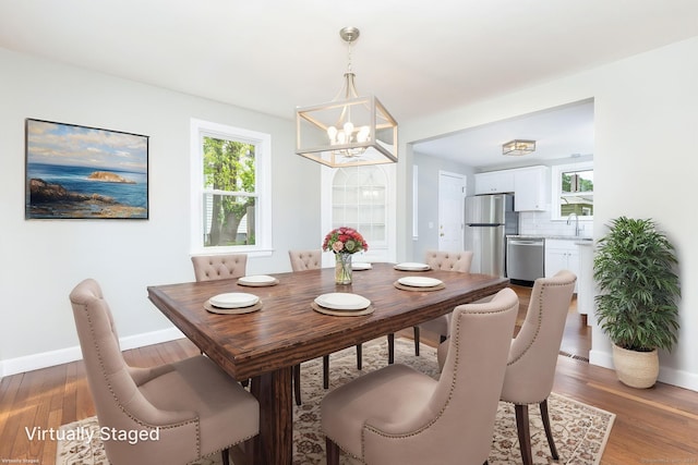 12 Pleasant Dr, Hamden, CT 06514 - dining space with a chandelier, baseboards, wood finished floors, and healthy amount of natural light