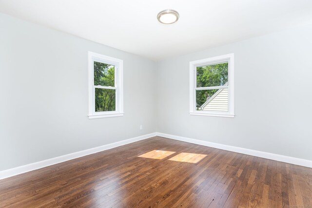 12 Pleasant Dr, Hamden, CT 06514 - unfurnished room with plenty of natural light, baseboards, and dark wood-style flooring