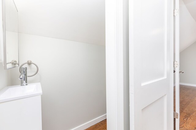 12 Pleasant Dr, Hamden, CT 06514 - bathroom featuring wood finished floors, baseboards, vaulted ceiling, and vanity