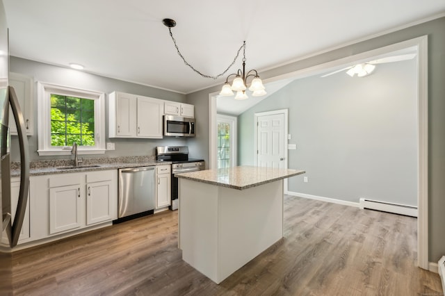 57 Quailcrest Rd, East Lyme, CT 06333 - kitchen with appliances with stainless steel finishes, a baseboard heating unit, a sink, light stone countertops, and wood finished floors