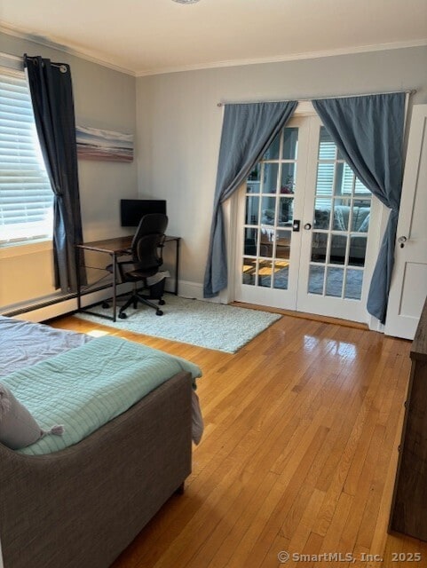 bedroom with ornamental molding, french doors, multiple windows, access to outside, and wood-type flooring