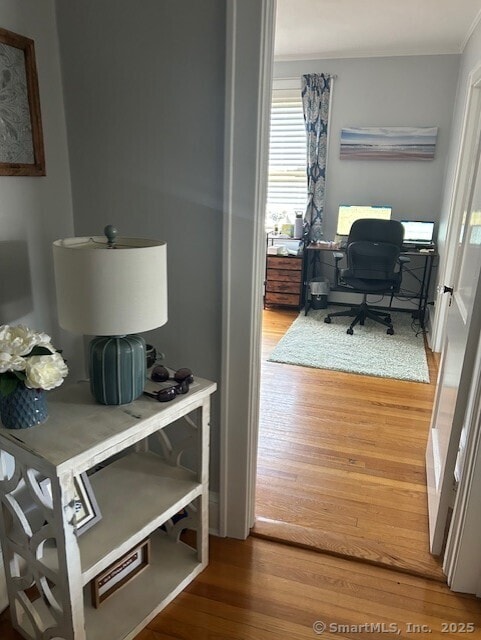 home office featuring wood finished floors and crown molding
