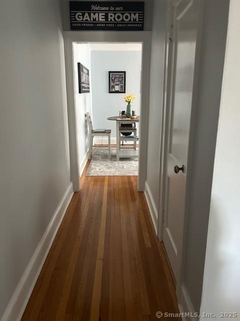 corridor with dark wood-style floors and baseboards