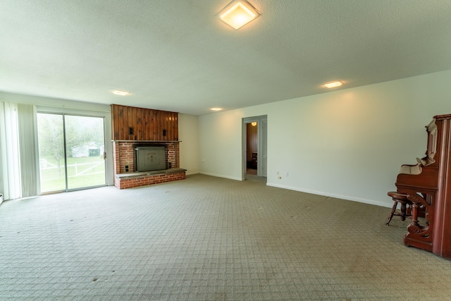 unfurnished living room with light carpet, a brick fireplace, a textured ceiling, and baseboards