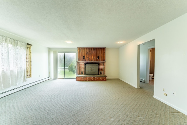 unfurnished living room featuring light colored carpet, a baseboard heating unit, a brick fireplace, and a textured ceiling