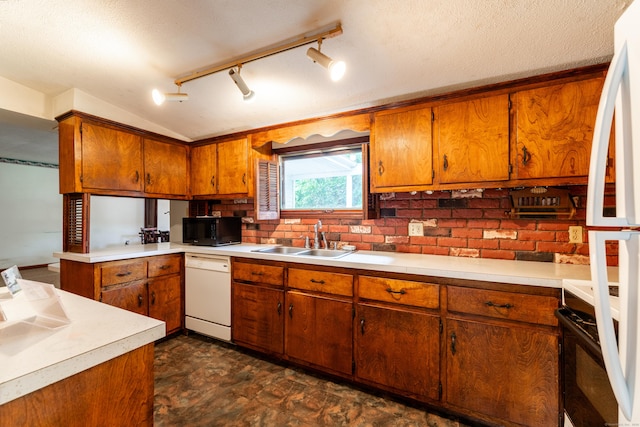 kitchen featuring white dishwasher, black microwave, a sink, and brown cabinets