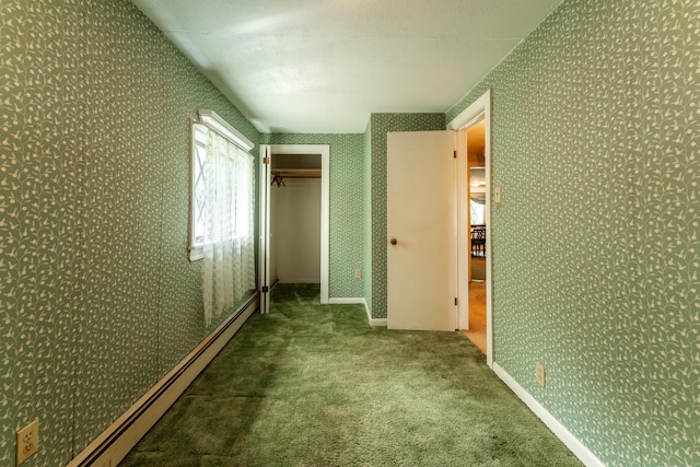 unfurnished bedroom featuring a baseboard radiator, carpet, wallpapered walls, and a closet