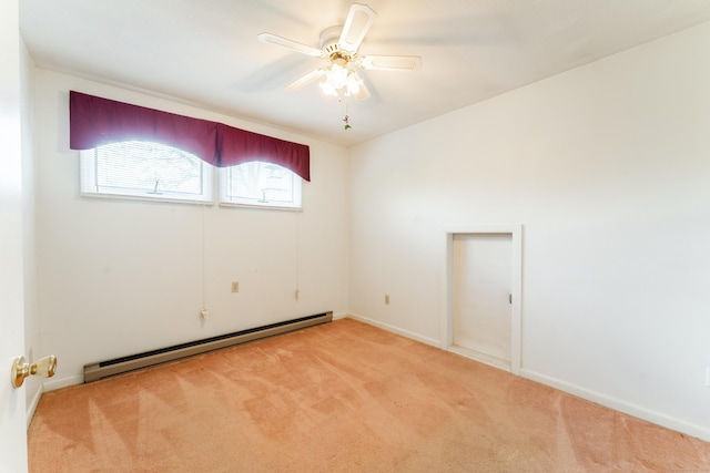 spare room featuring a baseboard radiator, light carpet, a ceiling fan, and baseboards
