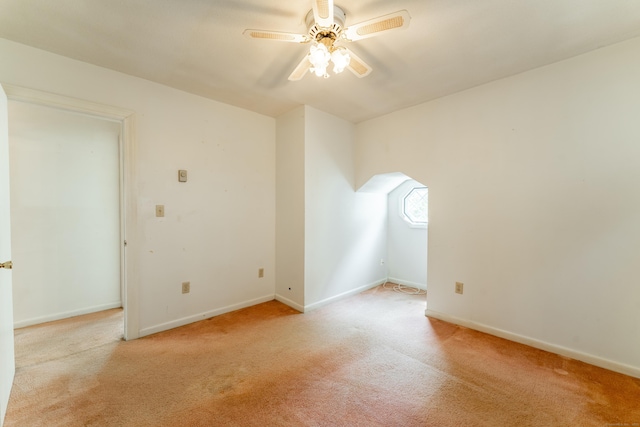 empty room with light colored carpet, ceiling fan, and baseboards