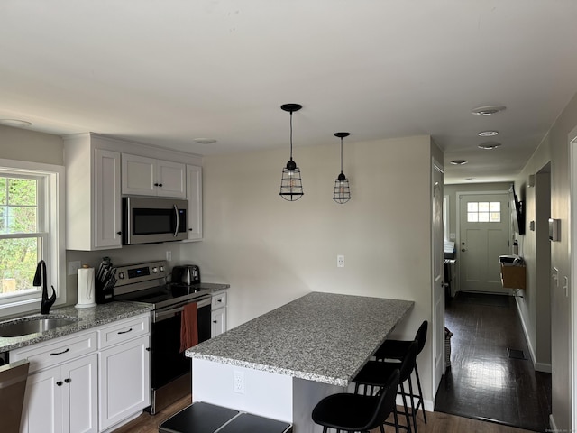 14 Russell St, Hamden, CT 06517 - kitchen featuring appliances with stainless steel finishes, light stone counters, a breakfast bar, and a peninsula
