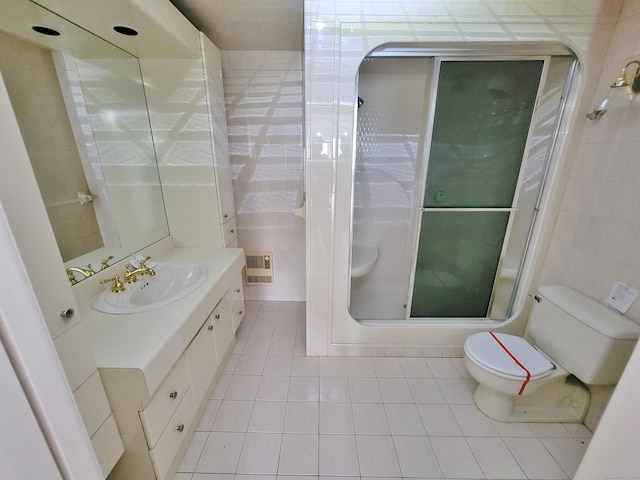 143 Hoyt St Apt 1F, Stamford, CT 06905 - bathroom featuring tile walls, tile patterned flooring, toilet, a stall shower, and vanity