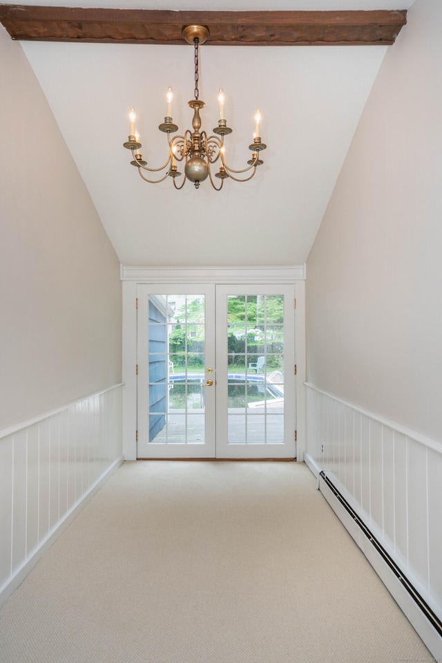empty room with baseboard heating, a chandelier, carpet floors, and vaulted ceiling