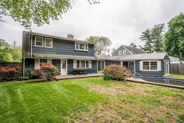 rear view of property with a chimney and a wooden deck