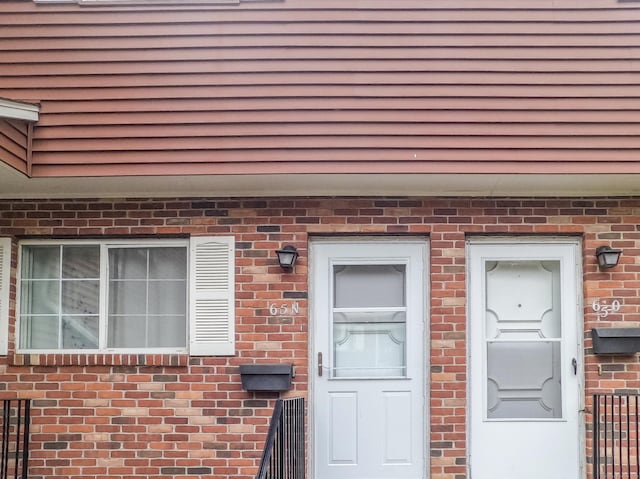 view of exterior entry featuring brick siding