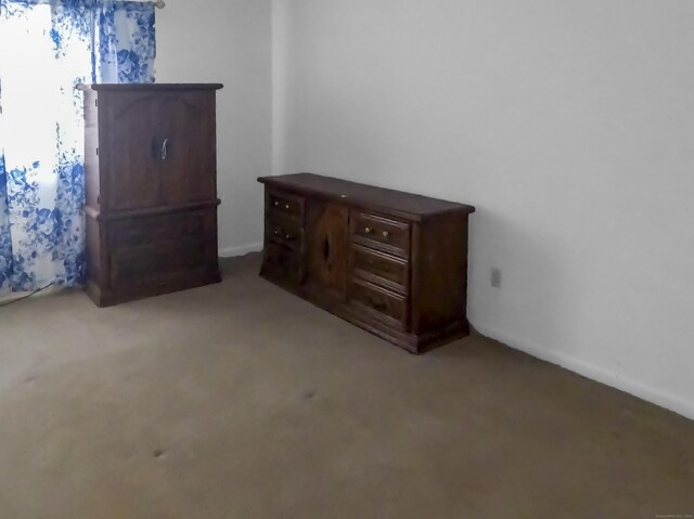 unfurnished bedroom with carpet floors and baseboards