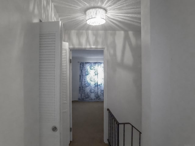 hallway featuring carpet flooring and a chandelier