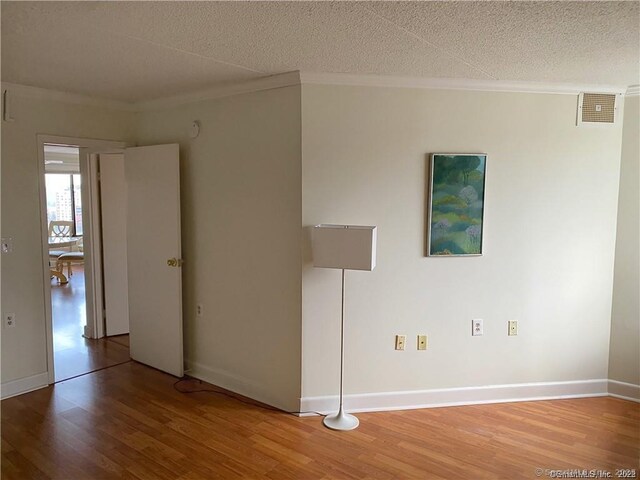 60 Strawberry Hill Ave Unit 1118, Stamford, CT 06902 - empty room featuring ornamental molding, light wood-style flooring, a textured ceiling, and baseboards