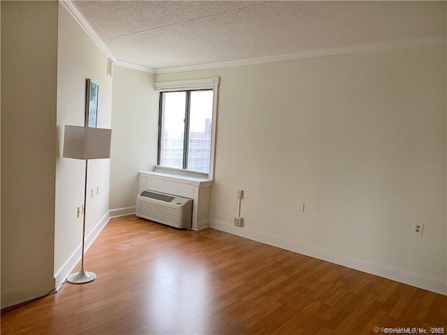 60 Strawberry Hill Ave Unit 1118, Stamford, CT 06902 - spare room featuring crown molding, a textured ceiling, wood finished floors, baseboards, and a wall unit AC