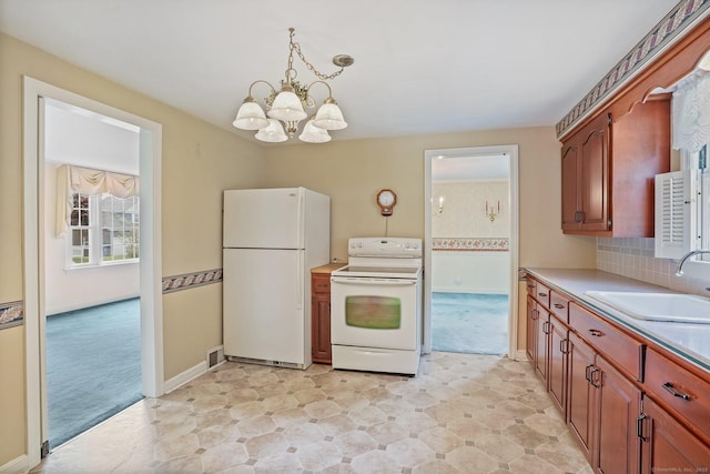 67 Matthew Dr, Stratford, CT 06614 - kitchen with white appliances, a sink, a chandelier, and light colored carpet