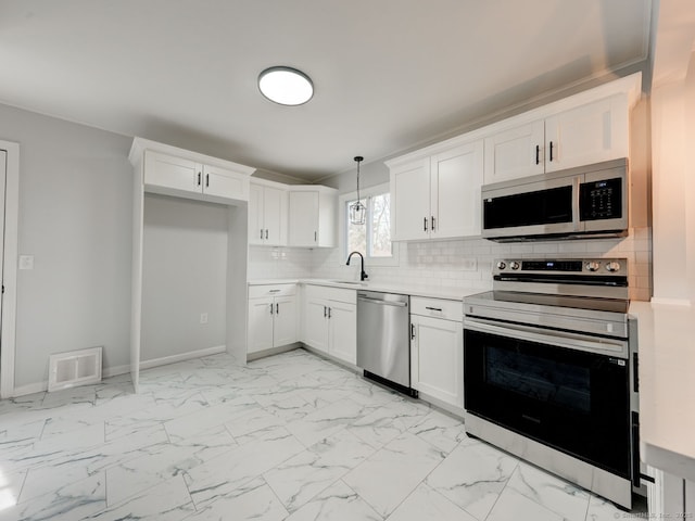 37 Austin Rd, Durham, CT 06422 - kitchen featuring appliances with stainless steel finishes, light countertops, a sink, white cabinetry, and decorative backsplash