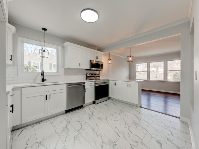 37 Austin Rd, Durham, CT 06422 - kitchen with appliances with stainless steel finishes, a sink, a peninsula, ornamental molding, and light marble finish floors