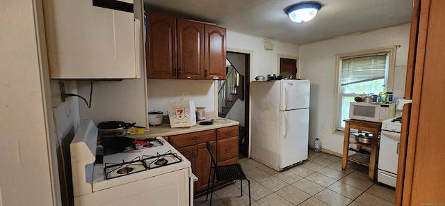 75 Clifton St, West Haven, CT 06516 - kitchen featuring white appliances, light countertops, light tile patterned flooring, and brown cabinetry