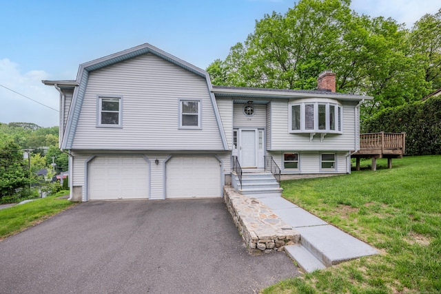 154 Williamson Dr, Waterbury, CT 06710 - raised ranch featuring a garage, asphalt driveway, a front lawn, and a chimney