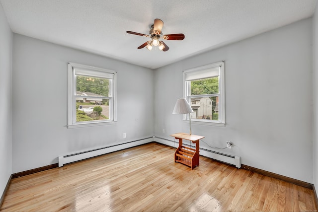 154 Williamson Dr, Waterbury, CT 06710 - empty room with plenty of natural light, a baseboard radiator, a ceiling fan, and wood finished floors