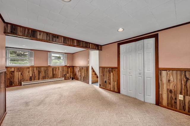154 Williamson Dr, Waterbury, CT 06710 - spare room with a baseboard radiator, wainscoting, wooden walls, stairs, and carpet