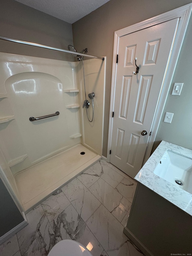 222 W Main St Apt 1C, Southington, CT 06479 - bathroom featuring a stall shower, marble finish floors, vanity, and a textured ceiling