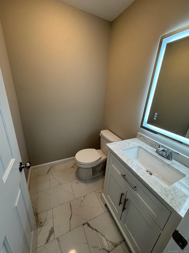 222 W Main St Apt 1C, Southington, CT 06479 - bathroom with marble finish floors, toilet, vanity, and baseboards