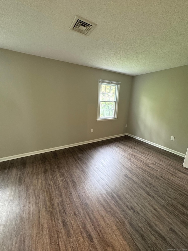 222 W Main St Apt 1C, Southington, CT 06479 - spare room with dark wood-style flooring, baseboards, and a textured ceiling