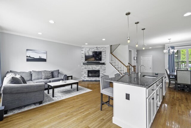 81 Tucker St Unit 81, Danbury, CT 06810 - kitchen with a sink, a kitchen bar, open floor plan, hardwood / wood-style flooring, and ornamental molding