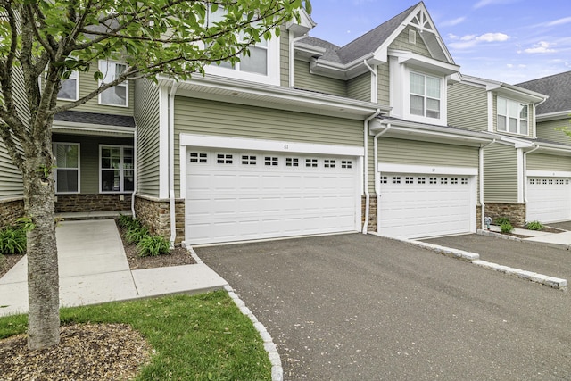 81 Tucker St Unit 81, Danbury, CT 06810 - townhome / multi-family property featuring stone siding, an attached garage, driveway, and a shingled roof