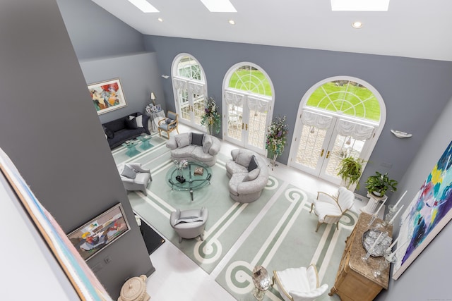 living room featuring a skylight, french doors, high vaulted ceiling, plenty of natural light, and recessed lighting