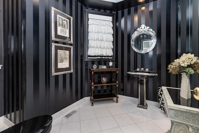 tiled foyer featuring baseboards and wallpapered walls